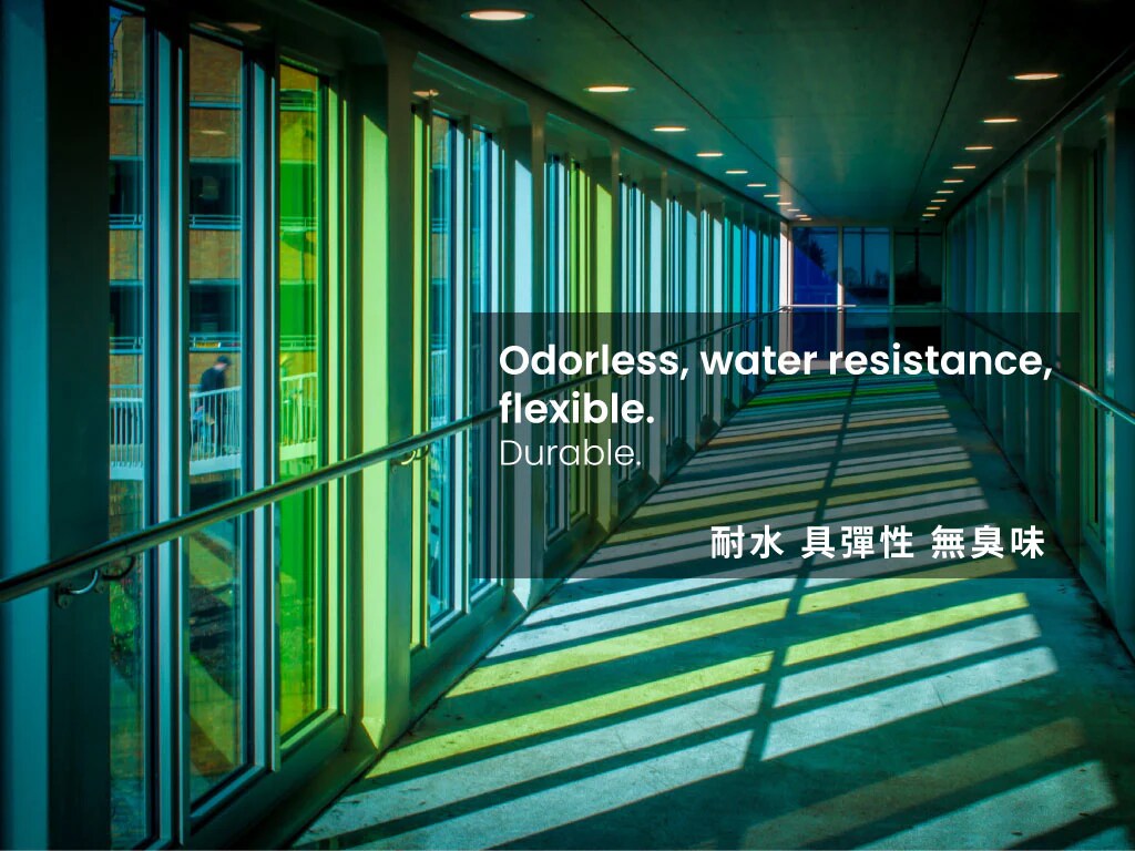 Modern building hallway featuring durable, odorless, water-resistant, and flexible sealant, showcasing vibrant, multi-colored light and shadow patterns through glass.