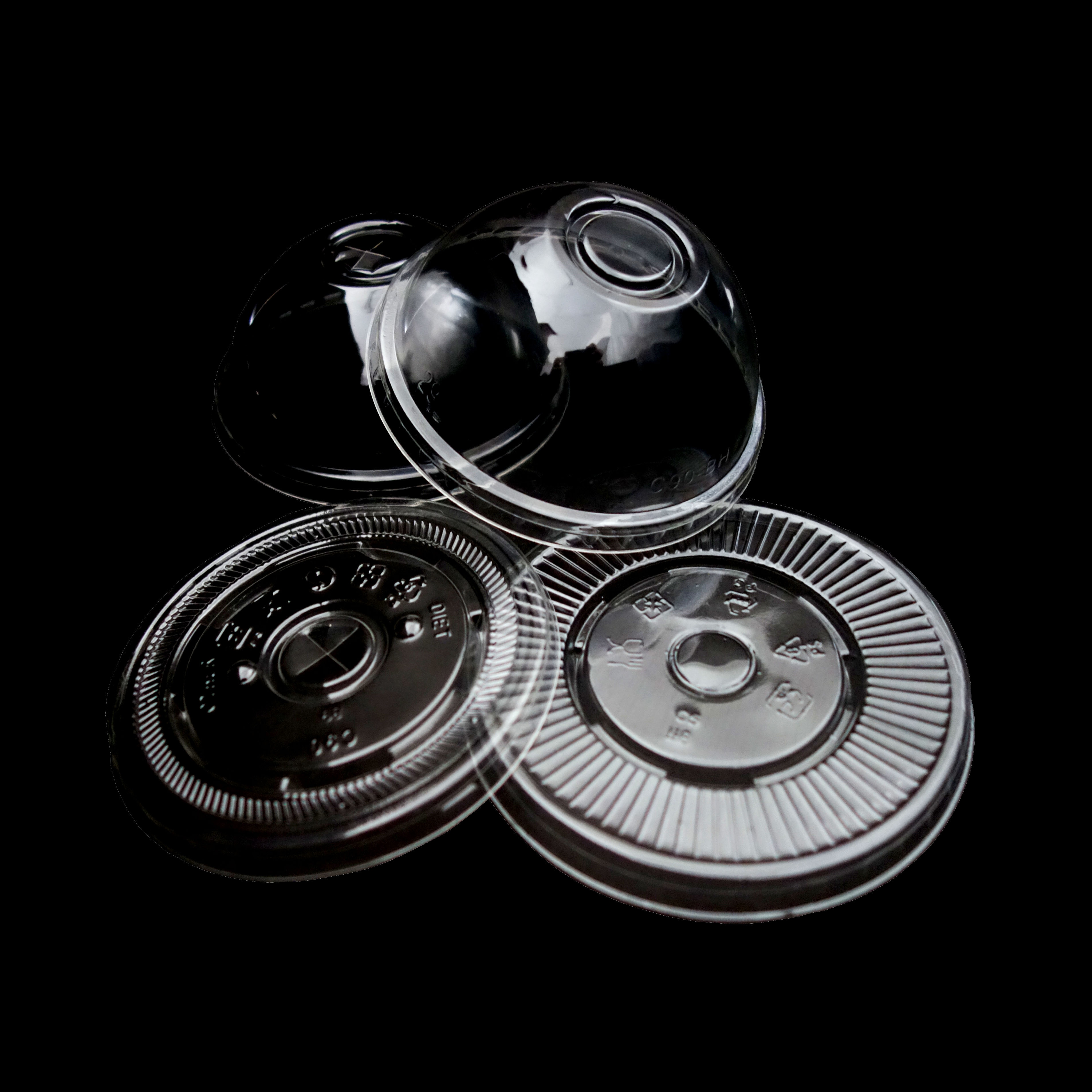 各种尺寸和直径的圆形透明塑料盖,带有用于吸管的孔.